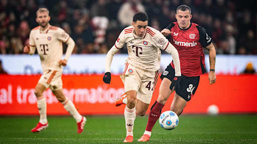 Jamal Musiala im Zweikampf mit Granit Xhaka im Bundesliga-Spiel des FC Bayern in Leverkusen.