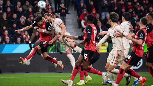 Harry geht ins Kopfballduell mit Piero Hincapie im Bundesliga-Spiel des FC Bayern in Leverkusen.