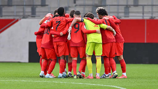 Die U19 des FC Bayern bildet einen Kreis vor dem Spiel.