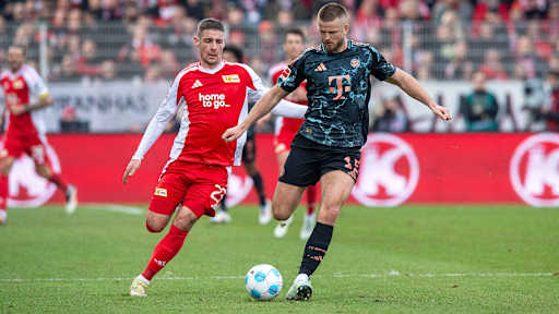 Eric Dier spielt einen Pass vor dem heranstürmenden Andrej ILic im Bundesliga-Spiel Union Berlin - FC Bayern