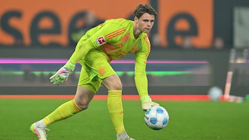 Jonas Urbig wirft einen Ball im Spiel des FC Bayern gegen den FC Augsburg