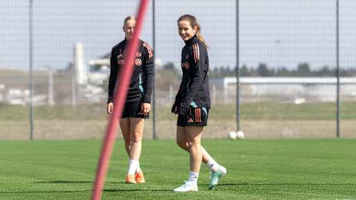 Tuva Hansen von den FC Bayern Frauen steht auf dem Trainingsplatz und lacht in die Kamera.