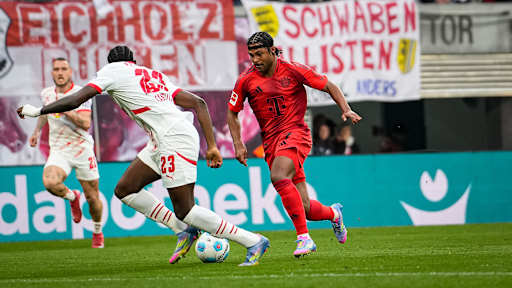 FC Bayerns Serge Gnabry im Zweikampf mit Leipzigs Castello Lukeba