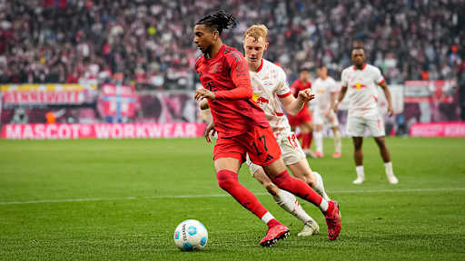 FC Bayerns Michael Olise im Zweikampf mit Leipzigs Nicolas Seiwald