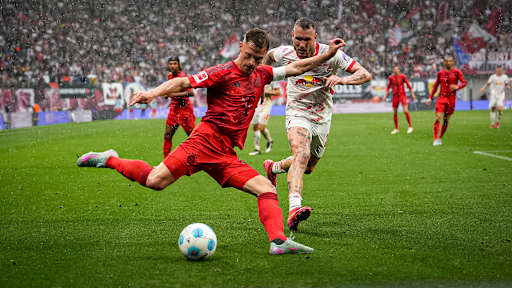 Joshua Kimmich flankt verfolgt von David Raum im Spiel des FC Bayern bei RB Leipzig