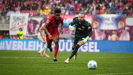 FC Bayerns Kingsley Coman im Laufduell mit Leipzigs Torwart Maarten Vandevoordt