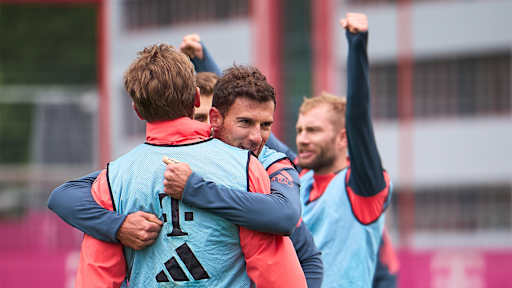 Leon Goretzka umarmt Harry Kane im öffentlichen Training des FC Bayern.