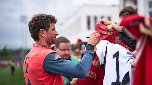 Thomas Müller schreibt Autogramme im öffentlichen Training des FC Bayern.
