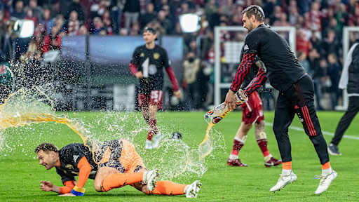 Der ausrutschende Manuel Neuer wird von Sven Ulreich mit Bier überschattet.