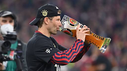 Thomas Müller trinkt aus einem großen Weißbierglas.