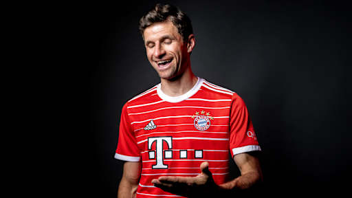 Thomas Müller schaut auf seine Hand und lacht