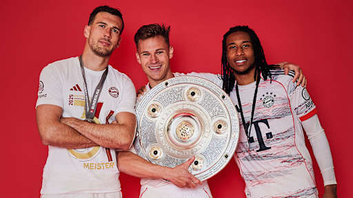 Leon Goretzka, Joshua Kimmich und Michael Olise vom FC Bayern jubeln mit der Meisterschale.