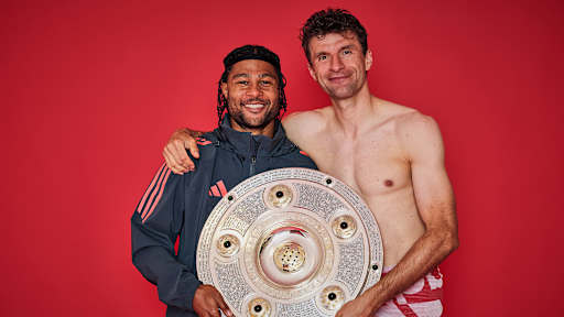 Serge Gnabry und Thomas Müller vom FC Bayern jubeln mit der Meisterschale.