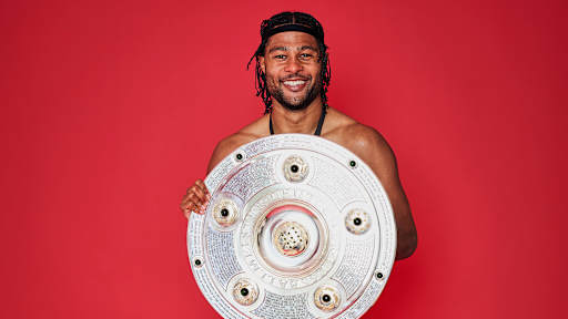 Serge Gnabry vom FC Bayern jubelt mit der Meisterschale.