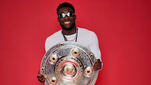 Alphonso Davies vom FC Bayern jubelt mit der Meisterschale.