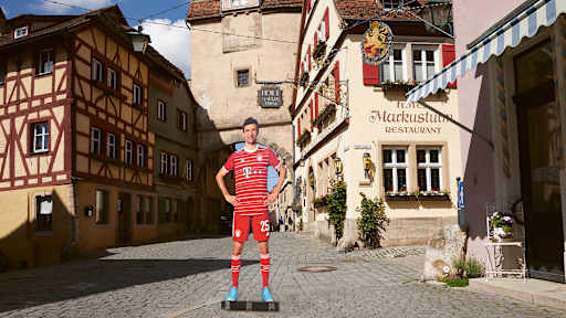 Lebensgroße Figuren von Thomas Müller aus dem FC Bayern-Museum stehen an bekannten Orten in Bayern