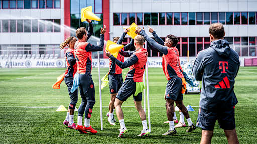 Spieler des FC Bayern werfen im Training mit Hütchen