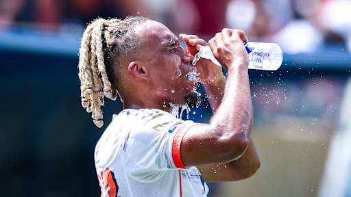 Sacha Boey schüttet sich Wasser ins Gesicht im Spiel des FC Bayern gegen Benfica Lissabon bei der Klub-WM.