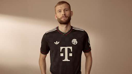 Konrad Laimer trägt das neue Champions League-Trikot des FC Bayern für die Saison 2025/26 in Schwarz mit roten, grünen und off-white Akzenten.