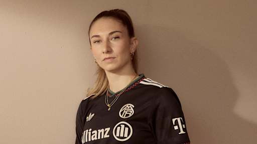 Katharina Naschenweng trägt das neue Champions League-Trikot des FC Bayern für die Saison 2025/26 in Schwarz mit roten, grünen und off-white Akzenten.