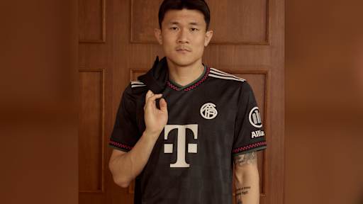 Minjae Kim trägt das neue Champions League-Trikot des FC Bayern für die Saison 2025/26 in Schwarz mit roten, grünen und off-white Akzenten.