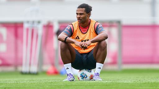 Serge Gnabry hockt auf einem Ball im Training des FC Bayern.