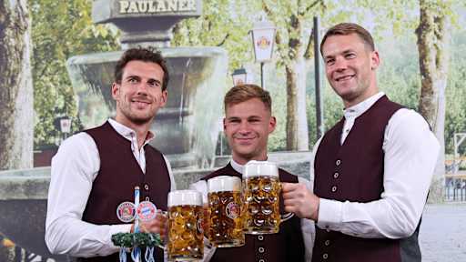 Leon Goretzka, Joshua Kimmich und Manuel Neuer stoßen mit Maßkrügen an