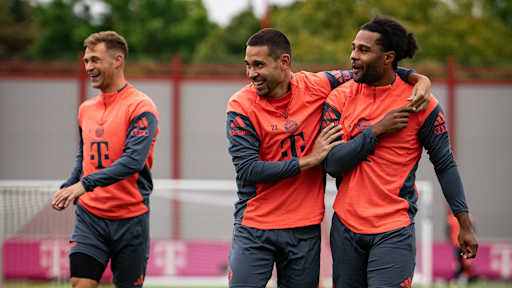 Raphael Guerreiro und Serge Gnabry lachen Arm in Arm im Training des FC Bayern