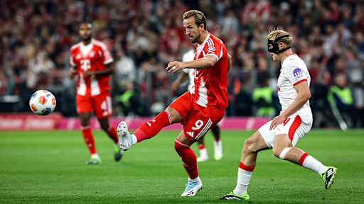 Harry Kane chippt den Ball während des Bundesligaauftakts zwischen dem FC Bayern und RB Leipzig