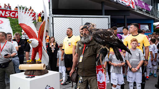 Ein Adler wird auf das Felf geführt vor dem Traumspiel des FC Bayern gegen den Fanclub Red Eagles Austria.