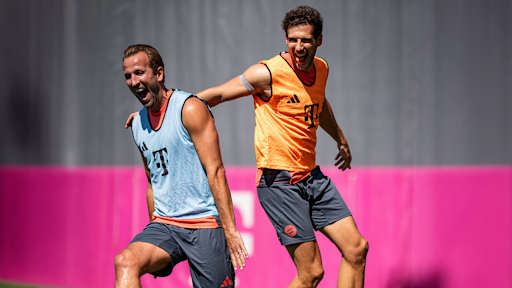Harry Kane und Leon Goretzka lachend beim Warmlaufen im Training des FC Bayern vor dem Pokalspiel in Wiesbaden.