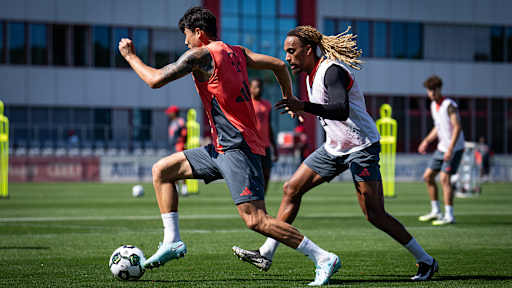 Mijae Kim verfolgt von Sacha Boey im Training des FC Bayern vor dem Pokalspiel in Wiesbaden.