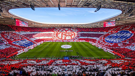 Die gefüllte Allianz Arena, mit Fans auf den Rängen, die das FC Bayern Logo in einer Stadion Choreographie abbilden.
