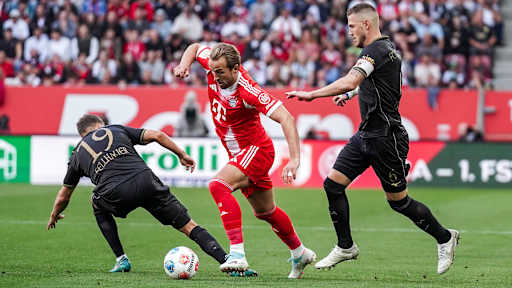 Harry Kane umdribbelt seinen Gegenspieler im Bundesliga-Spiel des FC Bayern beim FC Augsburg.