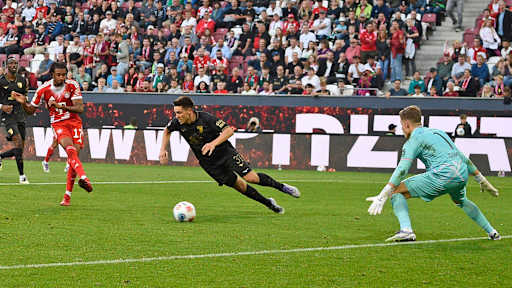Michael Olise schließt ab zum 3:0 im Bundesliga-Spiel des FC Bayern beim FC Augsburg.
