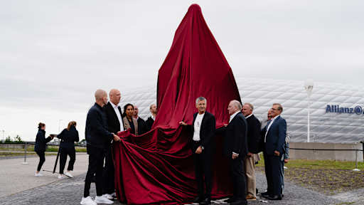 Herbert Hainer, Uli Hoeneß und weitere vor der verhüllten Statue von Franz Beckenbauer