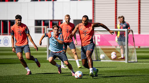 Jona Tah im orangenen Oberteil im FC Bayern-Training im Zweikampf mit Lenny Karl