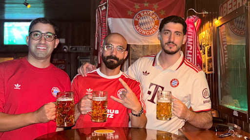 Die drei Bayernfans Stefanos, Andreas und Constantinos in Zypern in Trikots und mit Bierkrügen