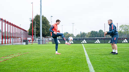 Jonas Urbig passt im Training des FC Bayern einen Ball