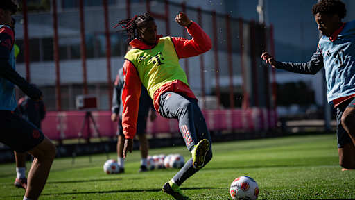 Michael Olise springt zum Ball im Abschlusstraining des FC Bayern vor dem Spiel bei Eintracht Frankfurt.