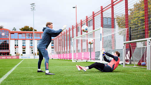Jonas Urbig fängt im Training des FC Bayern einen Ball