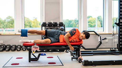 Jamal Musiala macht im Trainingszentrum des FC Bayern Stabilitätsübungen im Zuge seiner Reha