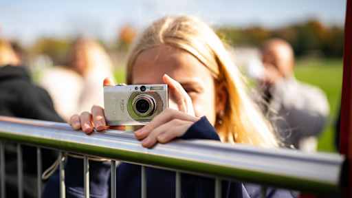Ein Mädchen fotografiert das öffentliche Training des FC Bayern