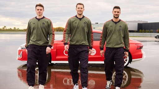 Jonas Urbig, Manuel Neuer und Sven Ulreich laufen vor einem roten Audi