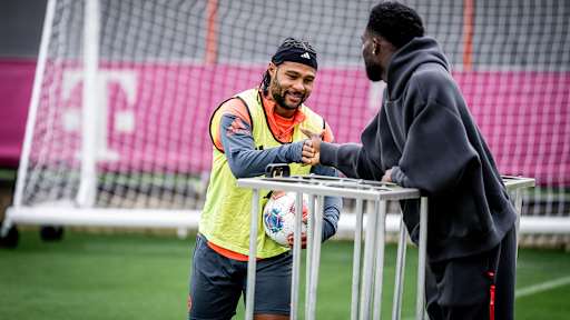 Serge Gnabry begrüßt Alphonso Davies im Training des FC Bayern vor dem Spitzenspiel gegen Dortmund