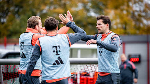 Harry Kane und Leon Goretzka klatschen ab im Training des FC Bayern vor dem Spitzenspiel gegen Dortmund