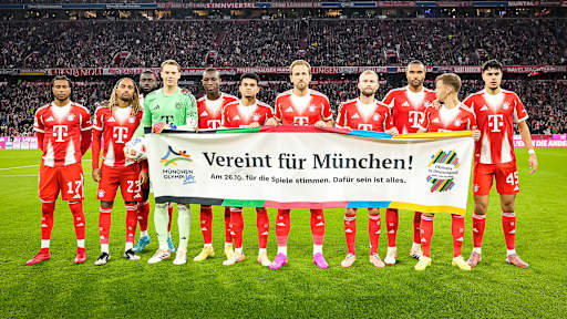 Die Mannschaft des FC Bayern hält einen Banner anlässlich Münchens Bewerbung für die Olympischen Sommerspiele