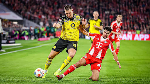 Aleksandar Pavlović grätscht während des Bundesliga-Heimspiels des FC Bayern gegen Borussia Dortmund