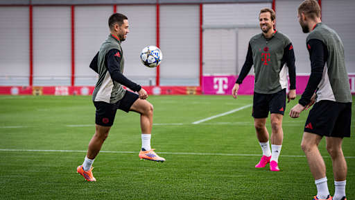 Raphael Guerreiro jongliert vor dem lachenden Harry Kane im Abschlusstraining des FC Bayern vor dem Spiel gegen Brügge