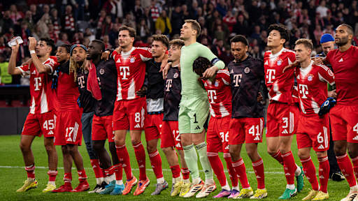 Spieler des FC Bayern jubeln nach dem Sieg gegen Brügge mit den Fans